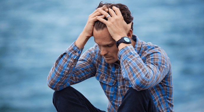 How does exercise help depression A depressed man sitting with his head in his hands